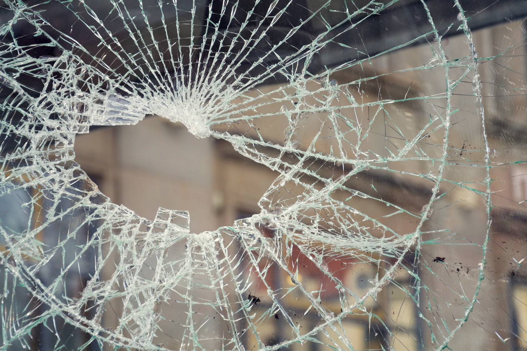 Hole in broken shattered security glass, insurance security crime concept